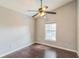 Bright bedroom features hardwood floors, a large window, and a ceiling fan for comfort at 6702 Imperial Oak Ln, Orlando, FL 32819