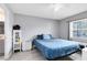 Comfortable bedroom with gray walls, light wood floors, ceiling fan, and bright natural light at 7741 Pine Hollow Ct, Orlando, FL 32822