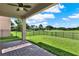 Covered back patio with brick pavers, ceiling fan, golf course view, and black metal fence at 8150 Prestbury Dr, Orlando, FL 32832