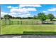 Scenic backyard view from the patio showcasing lush lawn and golf course views beyond the black metal fence at 8150 Prestbury Dr, Orlando, FL 32832