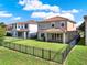 Exterior home view showcases a backyard with well-manicured lawn, fence, and covered patio at 8150 Prestbury Dr, Orlando, FL 32832
