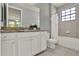 Traditional bathroom featuring a granite-topped vanity with white cabinets, a framed mirror and a tub shower combo at 8150 Prestbury Dr, Orlando, FL 32832