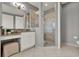 Bathroom vanity with granite countertops, white cabinets, framed mirror and a walk-in shower with glass door at 8150 Prestbury Dr, Orlando, FL 32832