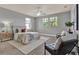 Comfortable bedroom with neutral decor, ceiling fan, a sitting area, and natural light from two windows at 8150 Prestbury Dr, Orlando, FL 32832