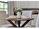 Close-up of a dining table with seating for four, complete with dinnerware and floral decorations at 8150 Prestbury Dr, Orlando, FL 32832