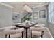 Dining room features modern chandelier, neutral colors, adjacent staircase, and large windows at 8150 Prestbury Dr, Orlando, FL 32832