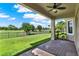 Covered patio providing views of the green golf course and a manicured lawn at 8150 Prestbury Dr, Orlando, FL 32832