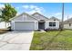 Charming single-story home with gray exterior, well-maintained lawn, and attached two-car garage at 831 Islander Ave, Orlando, FL 32825