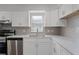 Modern kitchen with stainless steel appliances, white cabinets, and quartz countertops at 831 Islander Ave, Orlando, FL 32825