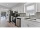 Updated kitchen featuring stainless appliances, quartz countertops, white cabinets, and ample natural light at 831 Islander Ave, Orlando, FL 32825