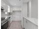 Modern kitchen featuring stainless appliances, gray tile backsplash, and white quartz countertops at 831 Islander Ave, Orlando, FL 32825