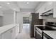 Bright kitchen with quartz counters, stainless appliances, sleek white cabinetry, and backyard view at 831 Islander Ave, Orlando, FL 32825