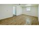 Bright bedroom featuring wood-look flooring, white walls and trim, and natural light from a window at 934 Savannah Ave, Lakeland, FL 33815
