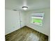 Bedroom featuring wood-look floors, white trim, and a window overlooking a backyard at 934 Savannah Ave, Lakeland, FL 33815