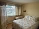 Cozy bedroom features a comfortable bed, light wood floors and a bright window at 5964 Peregrine Ave # C02, Orlando, FL 32819