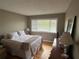 Comfortable bedroom featuring hardwood floors, a queen bed, and a bright window at 5964 Peregrine Ave # C02, Orlando, FL 32819