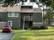 Charming two-story condo with lush green lawn, exterior staircase, and a parking space at 5964 Peregrine Ave # C02, Orlando, FL 32819