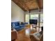 Bright living room featuring hardwood floors, wood beamed ceilings and a large window at 5964 Peregrine Ave # C02, Orlando, FL 32819