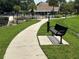 Community pool with palm trees is accessible via paved walkway with bench at 5964 Peregrine Ave # C02, Orlando, FL 32819
