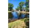Tranquil view of waterfront townhomes surrounding a lush, landscaped pond with fountain at 5964 Peregrine Ave # C02, Orlando, FL 32819