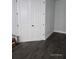 Bedroom featuring sleek, gray wood-look tiling and a bright closet with painted doors at 0 Overton St, Orlando, FL 32833