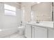 Bright bathroom with white cabinets, marble countertop, tub with shower and window at 10 Alicante Ct, Kissimmee, FL 34758
