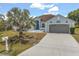 Single story light blue home with a large gray garage door and a palm tree in the front yard at 10 Alicante Ct, Kissimmee, FL 34758