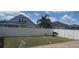 Spacious backyard with a white fence, lush green grass, and a grill, perfect for outdoor entertaining at 10658 Bannan St, Orlando, FL 32832