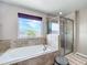 Elegant bathroom showcasing a soaking tub and glass-enclosed shower with natural light at 10658 Bannan St, Orlando, FL 32832