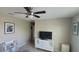 Neutral bedroom with ceiling fan, and a dresser with a TV; artfully decorated at 10658 Bannan St, Orlando, FL 32832