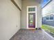 Exterior shot showing front porch with brick flooring, door with glass detail and welcome mat at 10658 Bannan St, Orlando, FL 32832