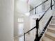 Bright staircase with white spindles and chandelier. View of the front door and hallway at 10658 Bannan St, Orlando, FL 32832