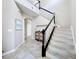 Staircase with carpeted steps, black handrail, white spindles and tiled flooring at the base at 10658 Bannan St, Orlando, FL 32832