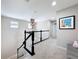 Upstairs hallway with carpet flooring, white trim, dark railing, and neutral wall paint at 10658 Bannan St, Orlando, FL 32832