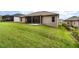 Back exterior view of house showcasing a manicured lawn and screened patio at 11255 Se 170Th Pl, Summerfield, FL 34491