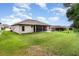 View of the backyard showing the green grass, and screen enclosed patio at 11255 Se 170Th Pl, Summerfield, FL 34491