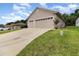 Home featuring a two-car garage with long driveway at 11255 Se 170Th Pl, Summerfield, FL 34491
