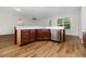 Kitchen island with seating, stainless steel dishwasher, and wood floors at 11255 Se 170Th Pl, Summerfield, FL 34491