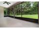 Screened patio with a ceiling fan and views of the green backyard and lush trees at 11255 Se 170Th Pl, Summerfield, FL 34491