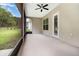 Spacious screened patio with ceiling fan, providing a relaxing outdoor living area overlooking the backyard at 11255 Se 170Th Pl, Summerfield, FL 34491