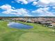 A golf course community with a scenic pond offering a peaceful and picturesque view from above at 13139 Stanthorne Ave, Orlando, FL 32832