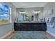 Elegant bathroom with a double vanity featuring granite countertops, a large mirror, and stylish lighting at 13139 Stanthorne Ave, Orlando, FL 32832