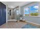 Modern bathroom with a large walk-in shower, wood-look tile flooring, and a bright window at 13139 Stanthorne Ave, Orlando, FL 32832