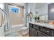 Bright bathroom featuring a shower-tub combo, granite counters and wood-look tile floors at 13139 Stanthorne Ave, Orlando, FL 32832