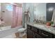 Bright bathroom featuring a shower-tub combo with patterned curtain, and granite vanity at 13139 Stanthorne Ave, Orlando, FL 32832