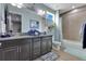 Bathroom with a double sink vanity, granite countertop, decorative mirror, and a shower/tub combination at 13139 Stanthorne Ave, Orlando, FL 32832