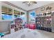 bedroom with a large dollhouse, bookshelf filled with toys, a pink beanbag, and multiple windows at 13139 Stanthorne Ave, Orlando, FL 32832