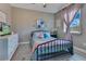 Cozy bedroom featuring a metal frame bed, dresser, neutral walls, and a window letting in natural light at 13139 Stanthorne Ave, Orlando, FL 32832