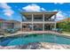 Rear exterior view of a two-story home with an outdoor bar, lounge and pool area at 13139 Stanthorne Ave, Orlando, FL 32832