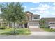 Charming two-story home features a stone facade, well-manicured lawn, and a spacious two-car garage at 13139 Stanthorne Ave, Orlando, FL 32832